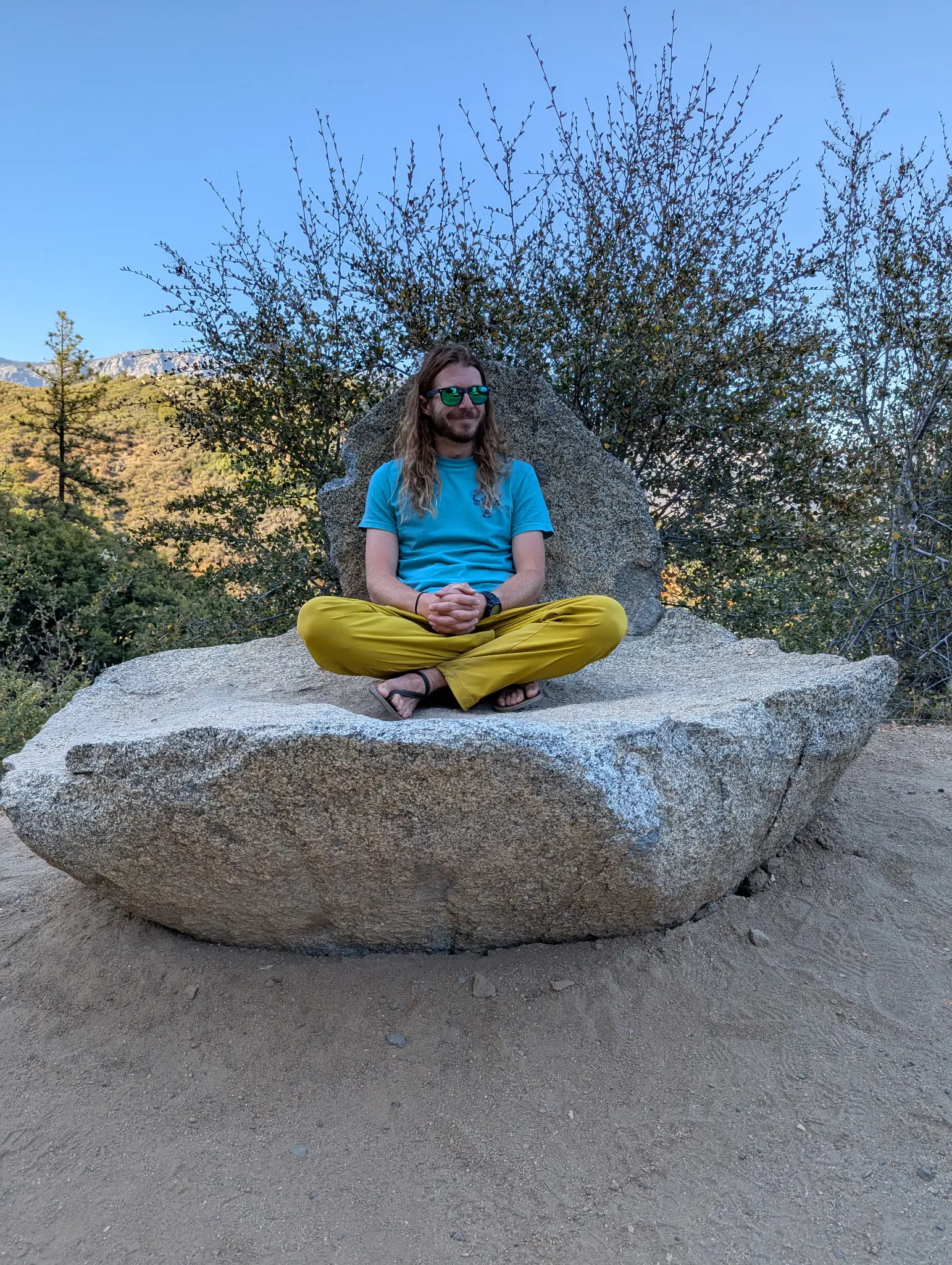 Yoga instructor Jacob sitting on a rock